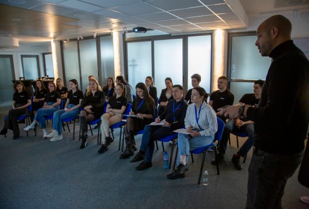 Attendees of the Master Class on Minimal Invasive Adhesive Dentistry listen closely and take notes as the instructor explains advanced clinical protocols in an engaging face-to-face session.