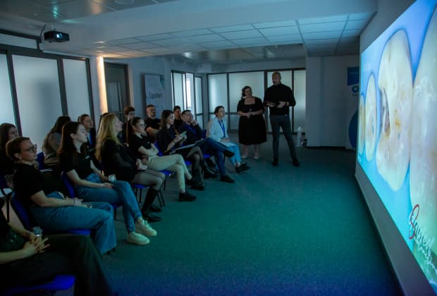 Participants examine high-resolution clinical images during a detailed lecture, enhancing their understanding of adhesive techniques and restorative outcomes.